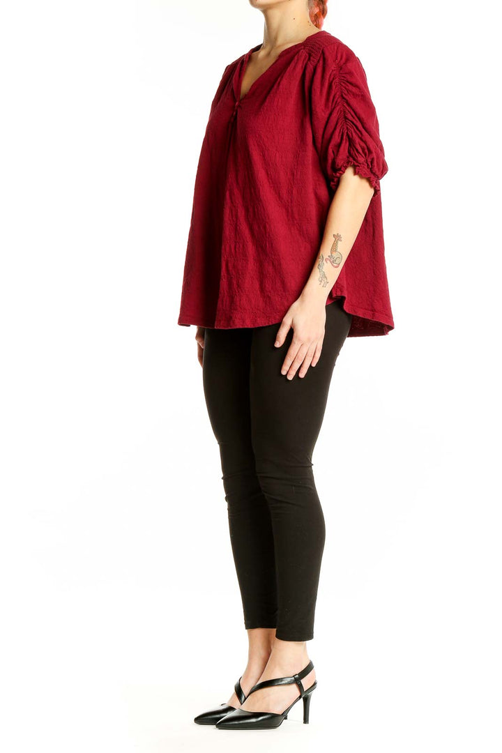 Front view of red Free People peasant blouse with ruched sleeves