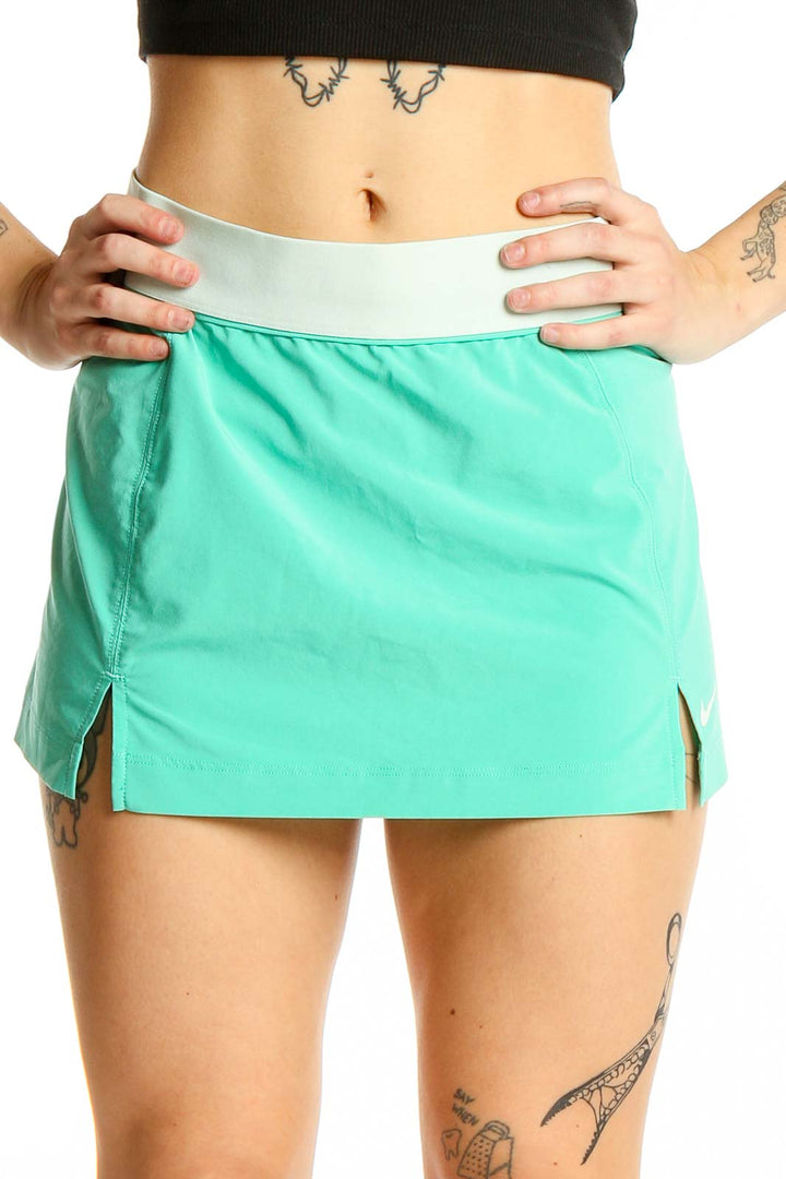 Front view of mint green Nike athletic mini skirt with white waistband