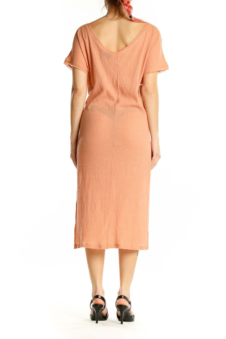 Back view of peach knit midi dress showing relaxed fit and midi length