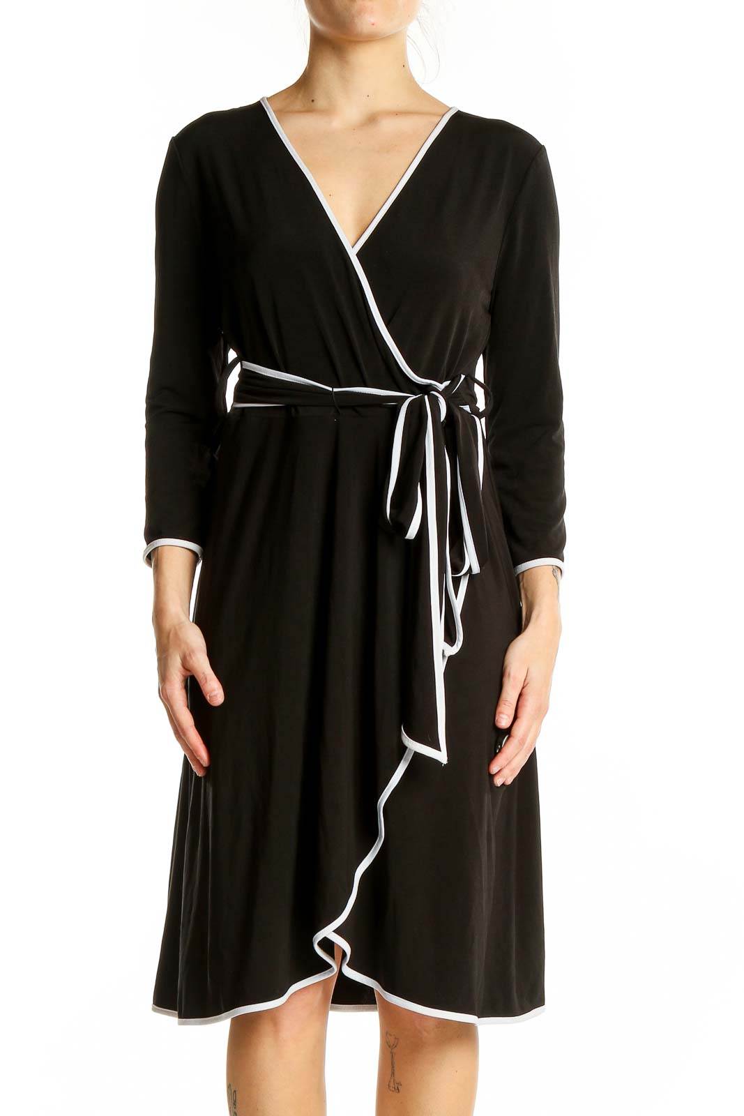 Front view of Calvin Klein black wrap dress with white trim and adjustable waist tie