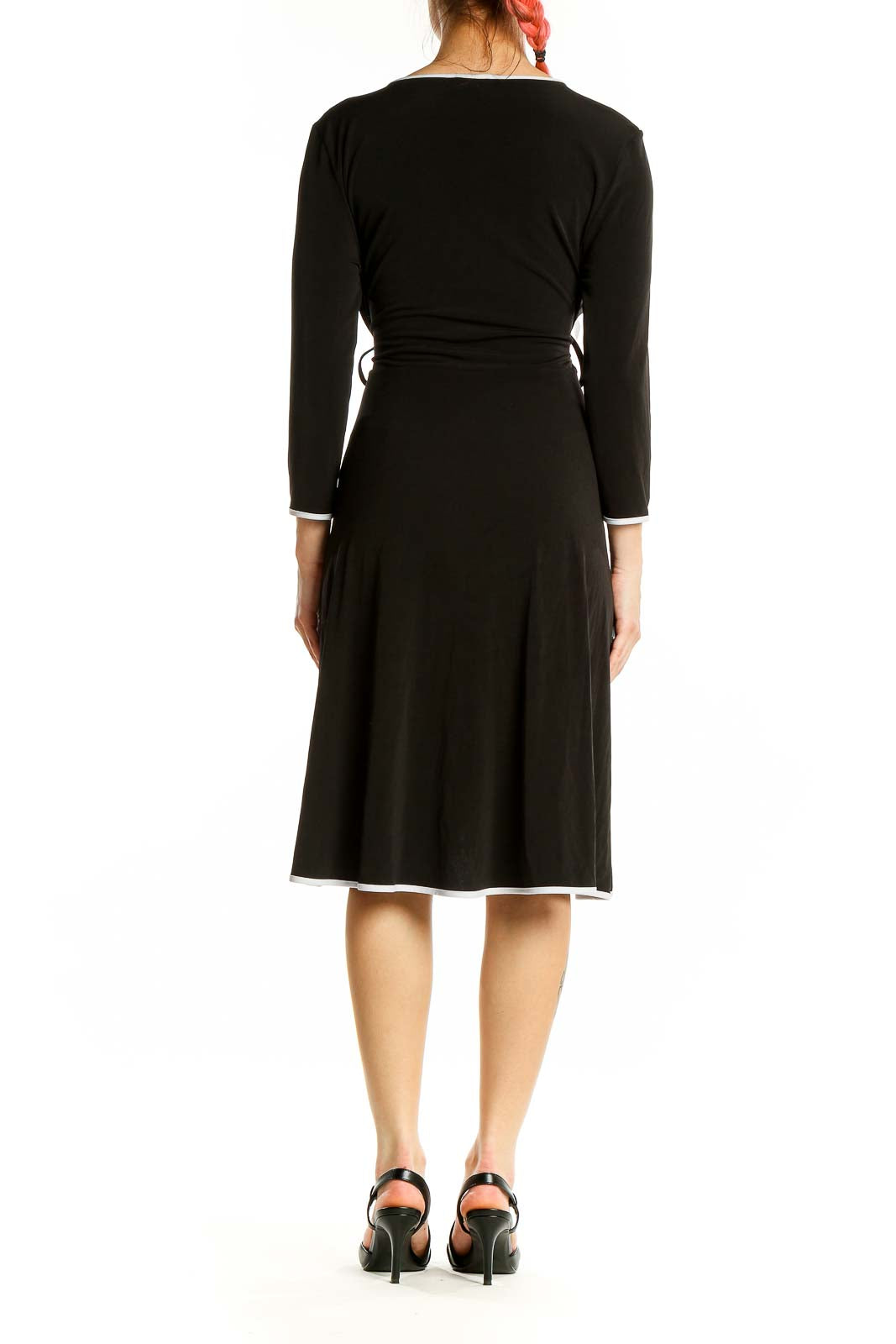 Back view of Calvin Klein black wrap dress showing knee-length design and white trim detail