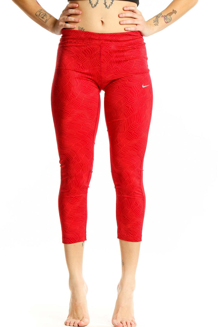 Front view of red textured Nike capri leggings on model