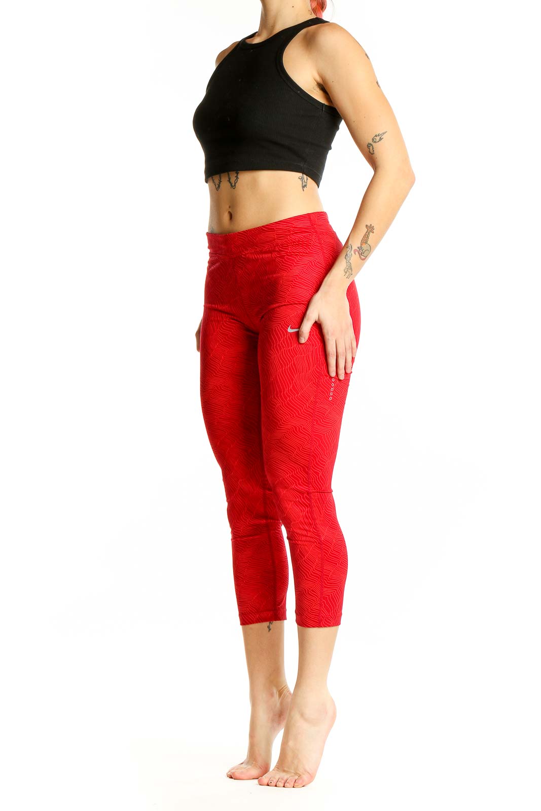 Front view of red textured Nike capri leggings on model