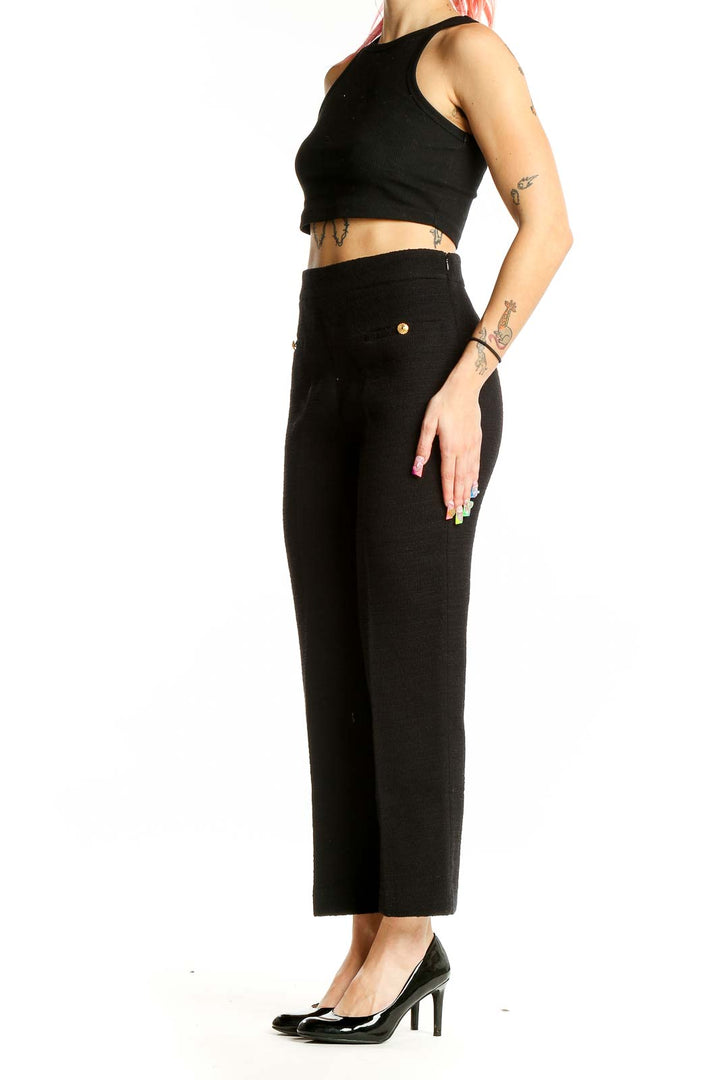 Front view of Zara black high-waisted tailored trousers with gold button accents