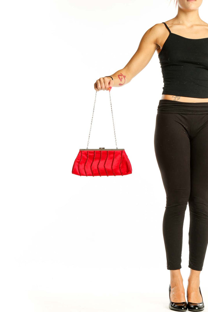 Front view of red satin SilkRoll clutch with beaded wave patterns and chain strap