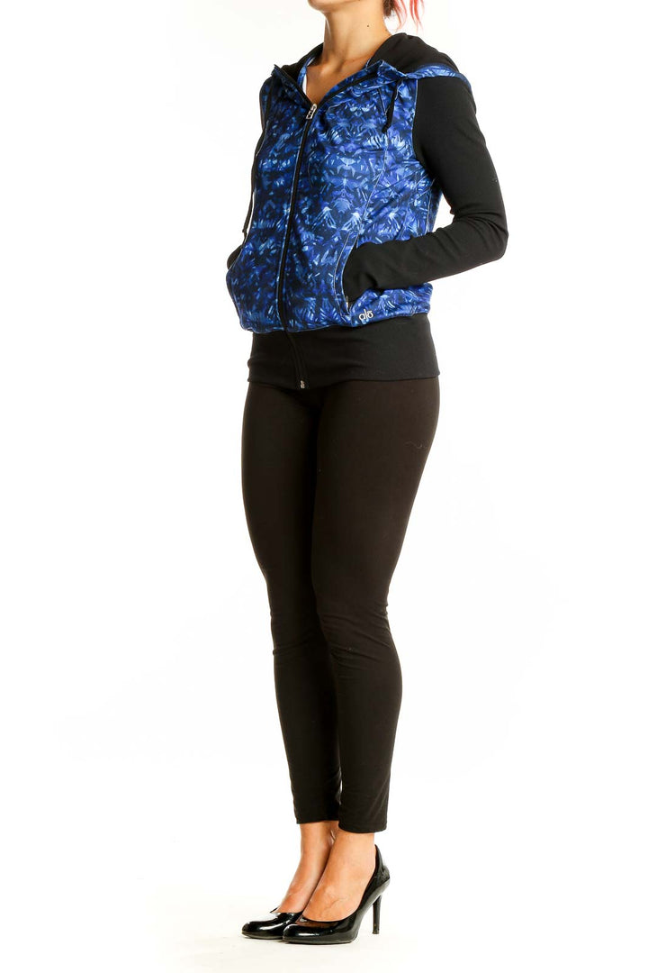 Front view of Alo Yoga blue patterned activewear jacket with black sleeves