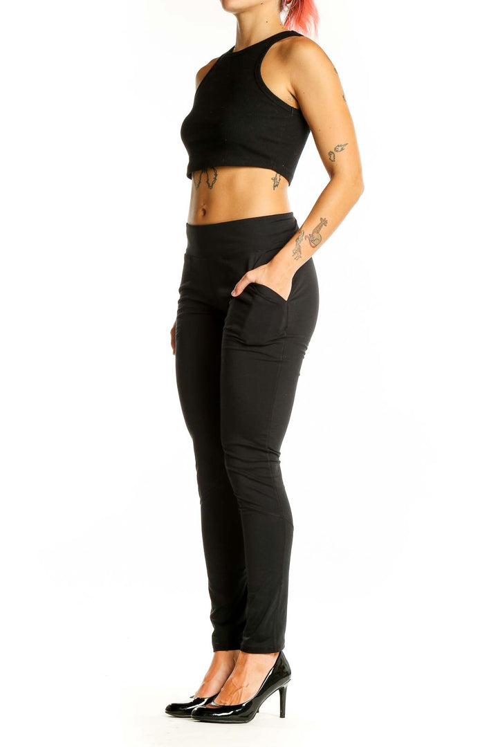 Front view of black Under Armour performance pants with elastic waistband