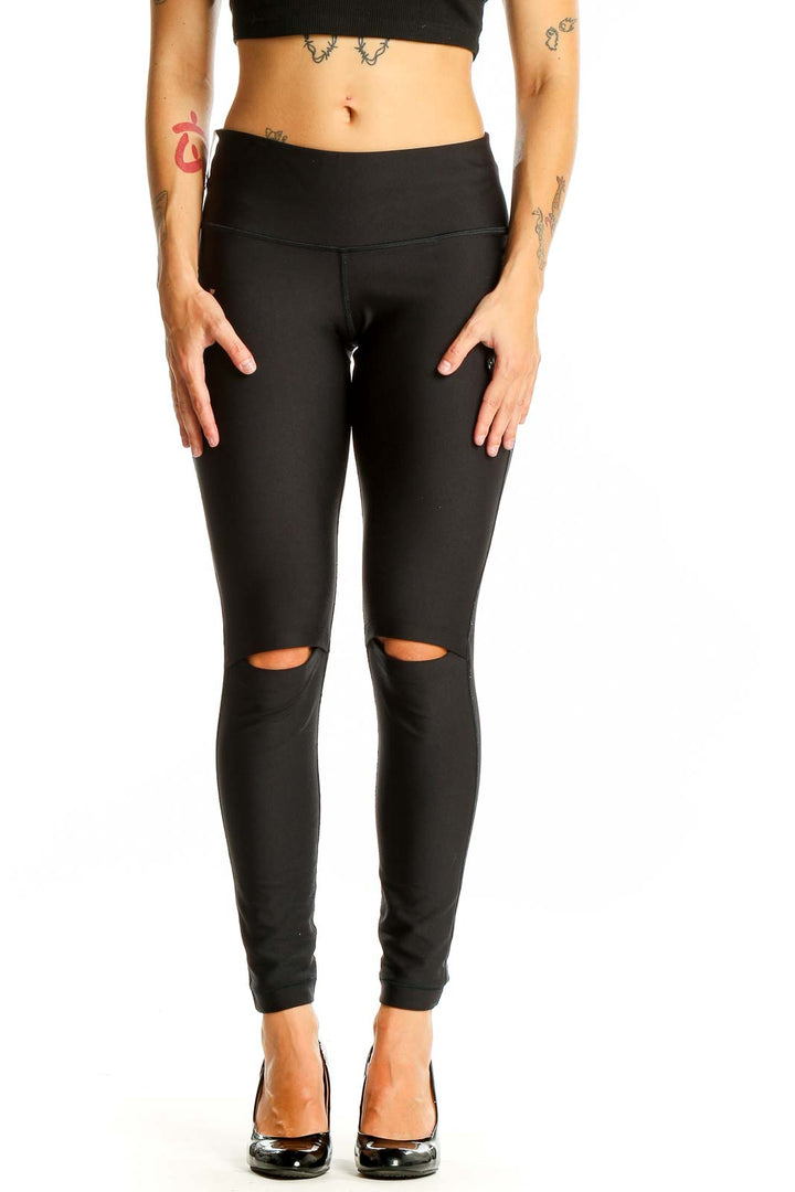 Front view of black Under Armour leggings with knee cutouts