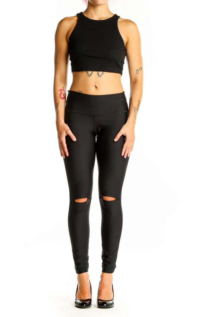 Front view of black Under Armour leggings with knee cutouts