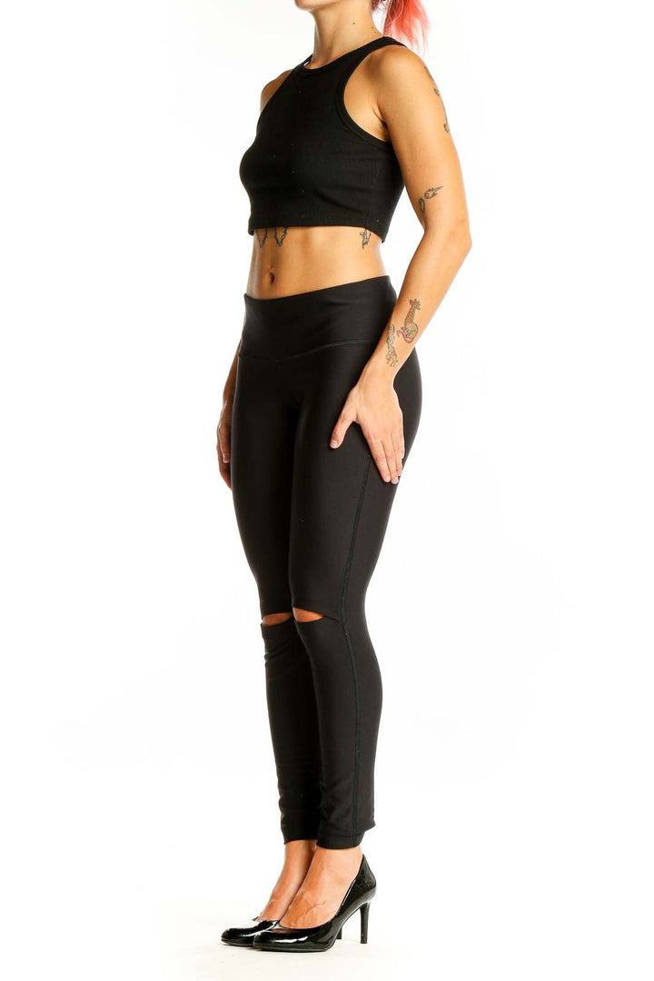 Front view of black Under Armour leggings with knee cutouts