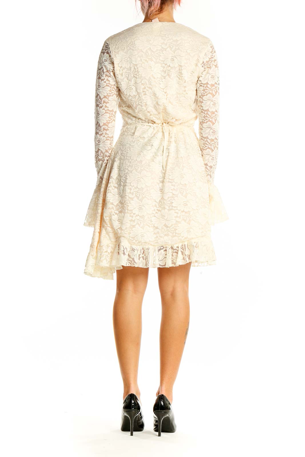 Back view of cream lace wrap mini dress showing ruffled hem and tie closure