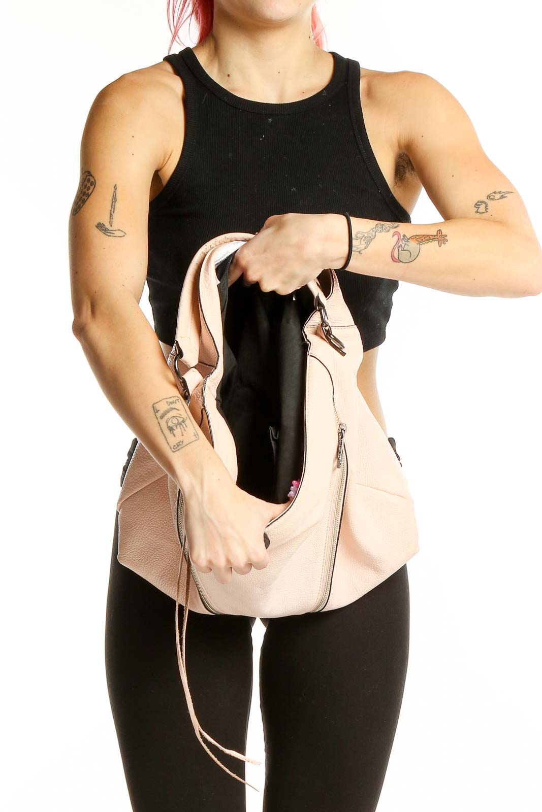 Model holding Rebecca Minkoff blush leather hobo shoulder bag