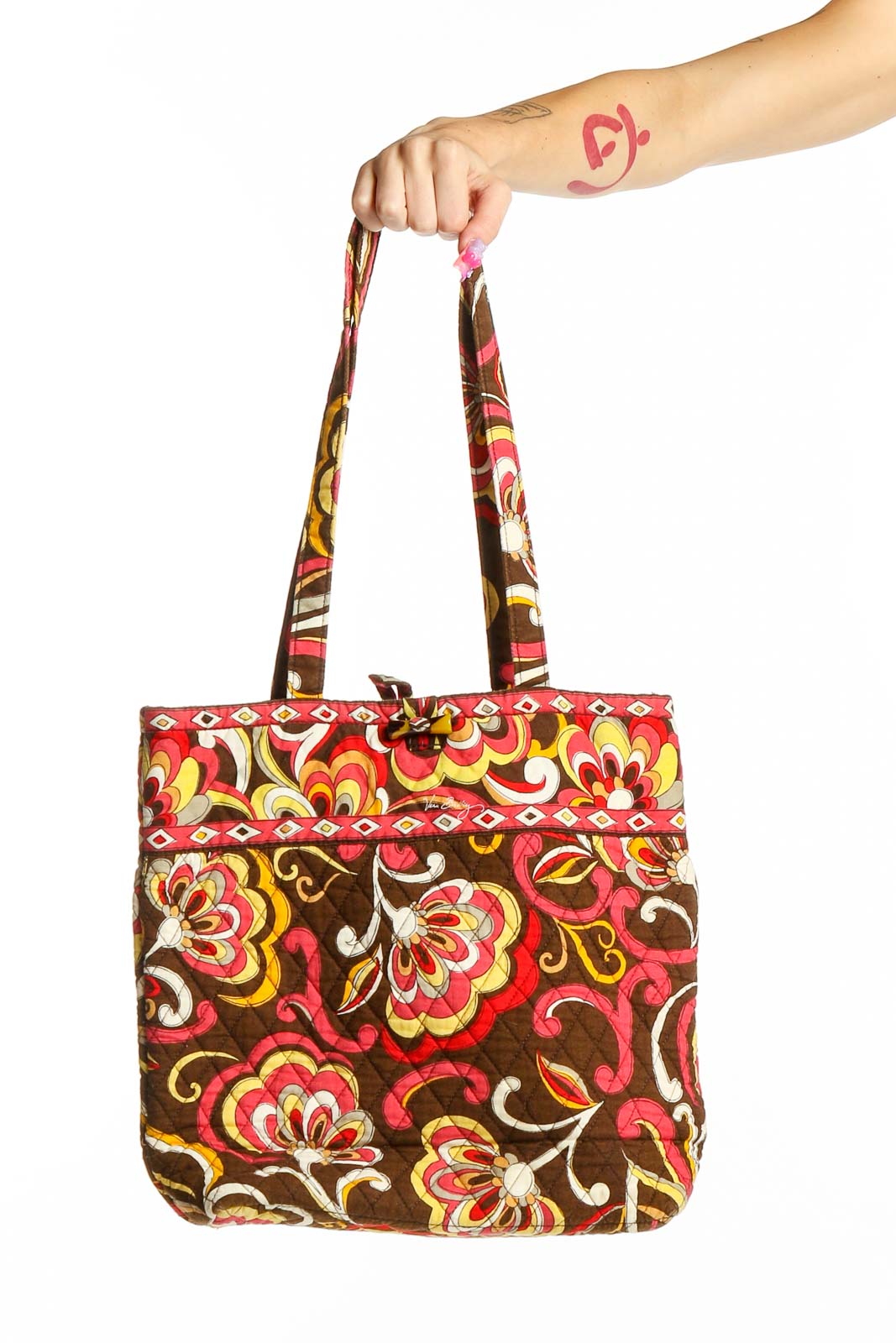 Front view of Vera Bradley brown floral quilted tote bag held by hand