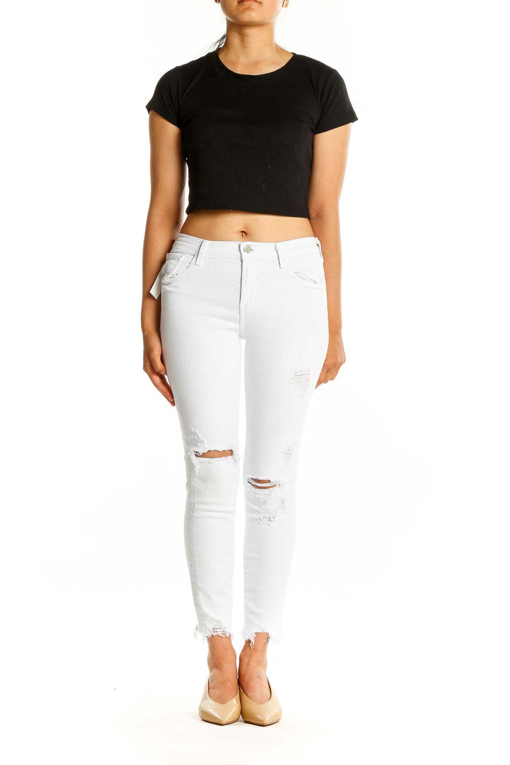 Front view of J Brand white distressed skinny jeans with ripped knees