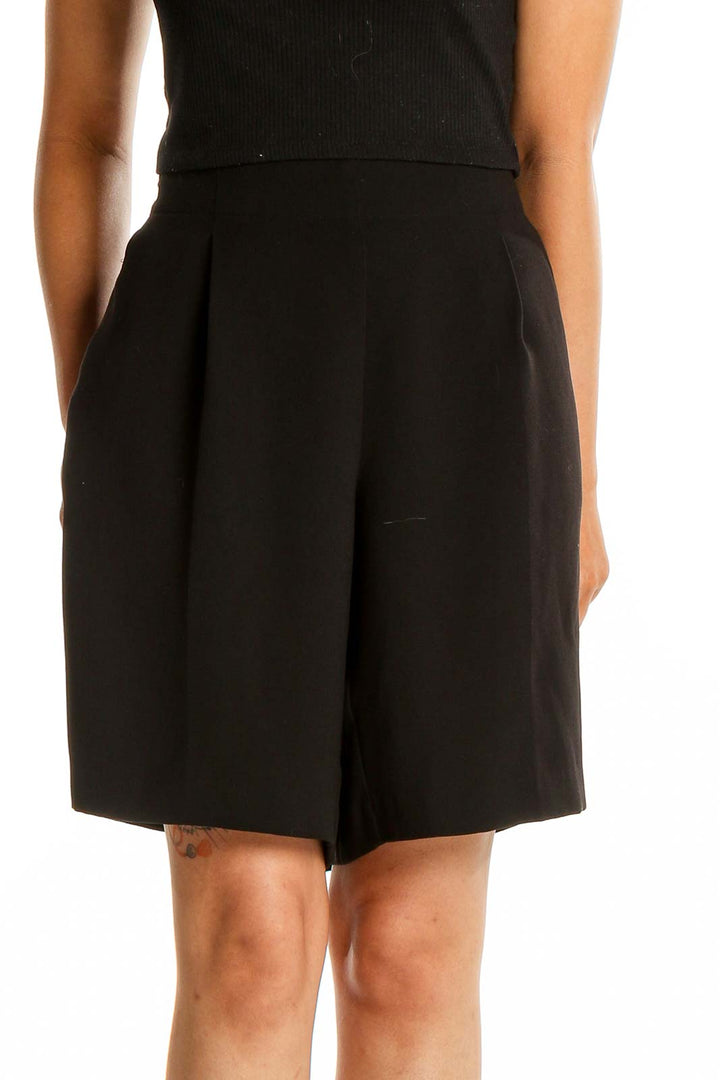 Front view of LOFT black pleated polyester shorts