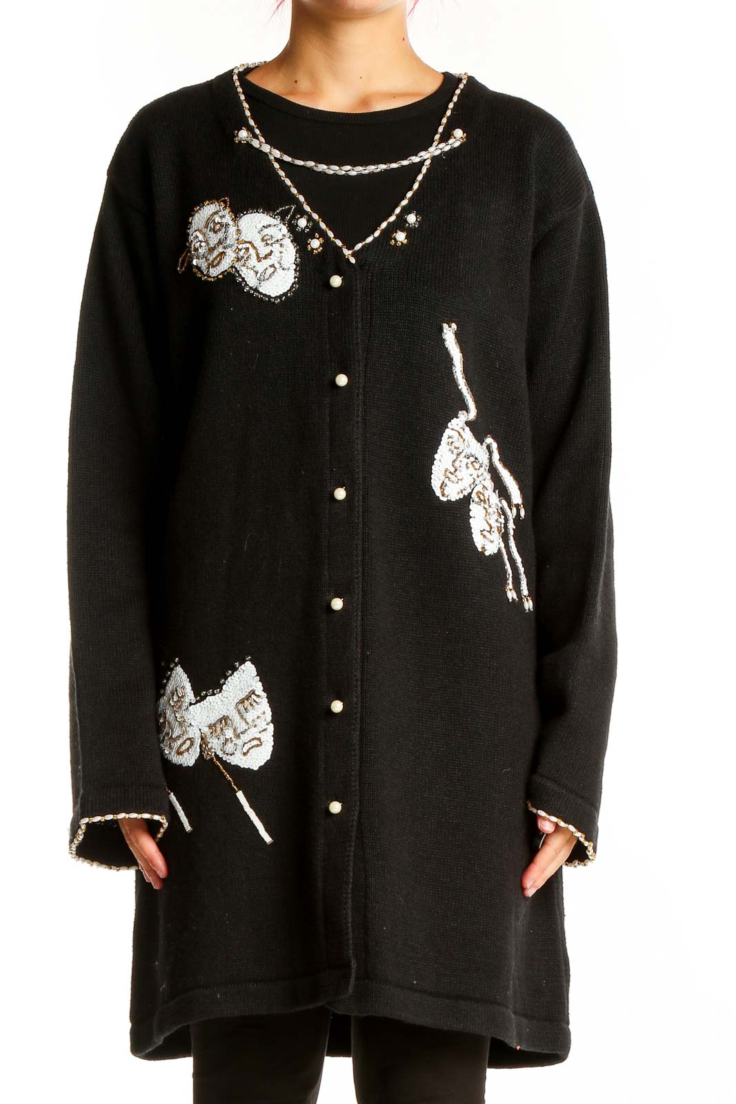 Front view of black Storybook Knits cardigan with theater mask appliques and pearl chain design