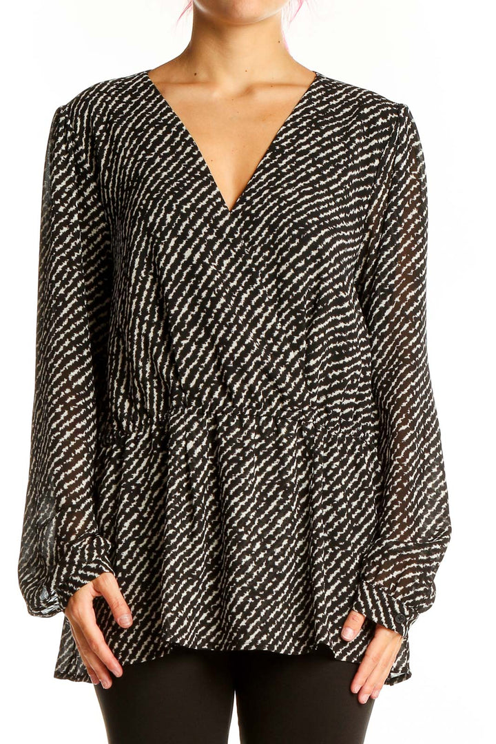 Front view of MICHAEL Michael Kors black and white patterned V-neck blouse with long sleeves