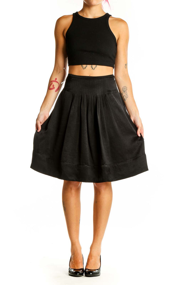 Front view of Ined black pleated A-line midi skirt on model