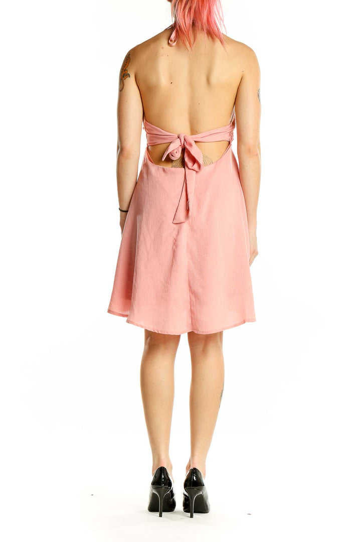 Back view of Flying Tomato pink halter sundress showing open back with tie closure