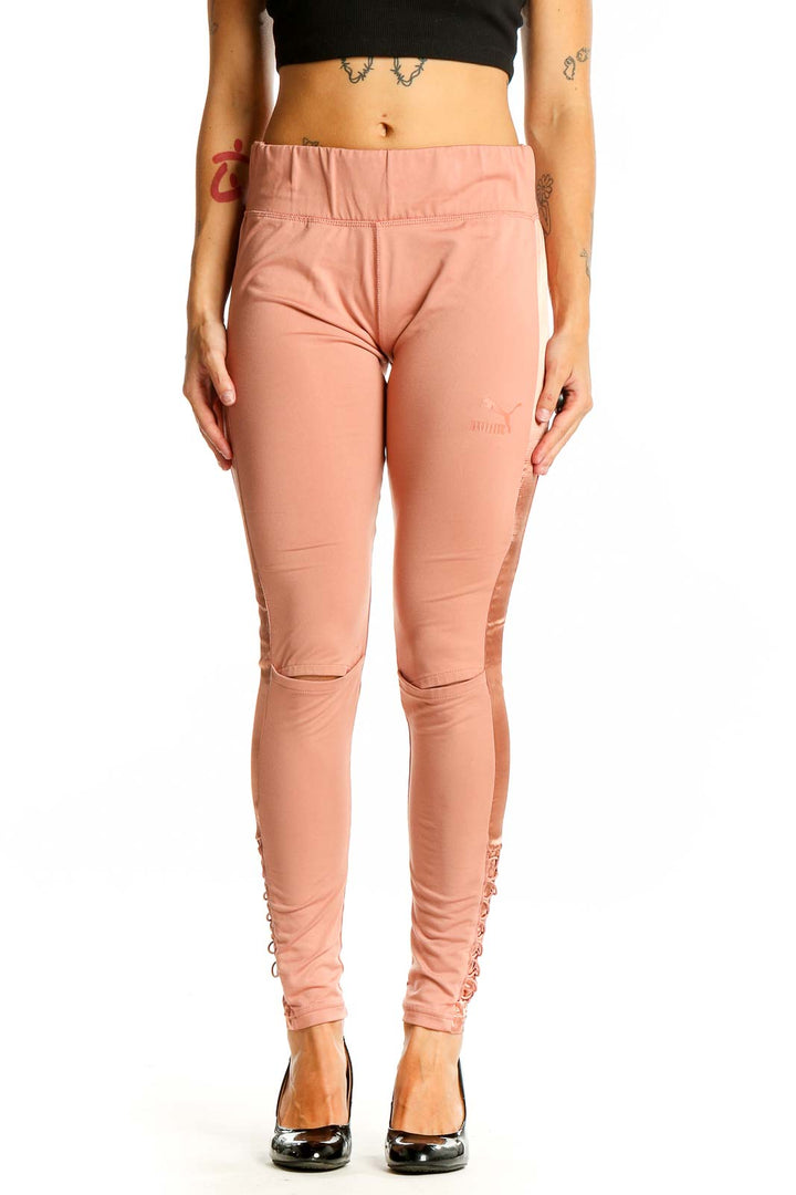 Front view of Puma peach high-waisted leggings with lace-up sides