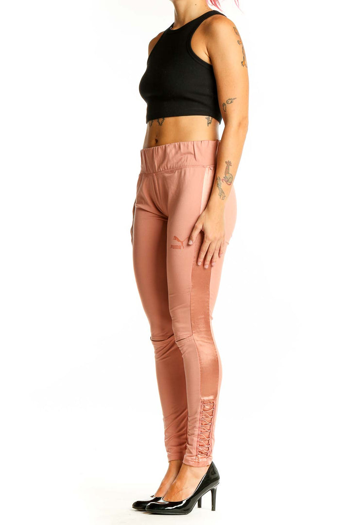 Front view of Puma peach high-waisted leggings with lace-up sides