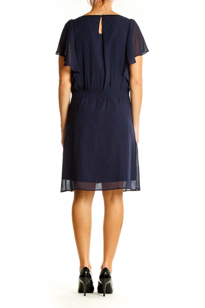 Back view of navy chiffon cocktail dress showing flutter sleeves and keyhole detail