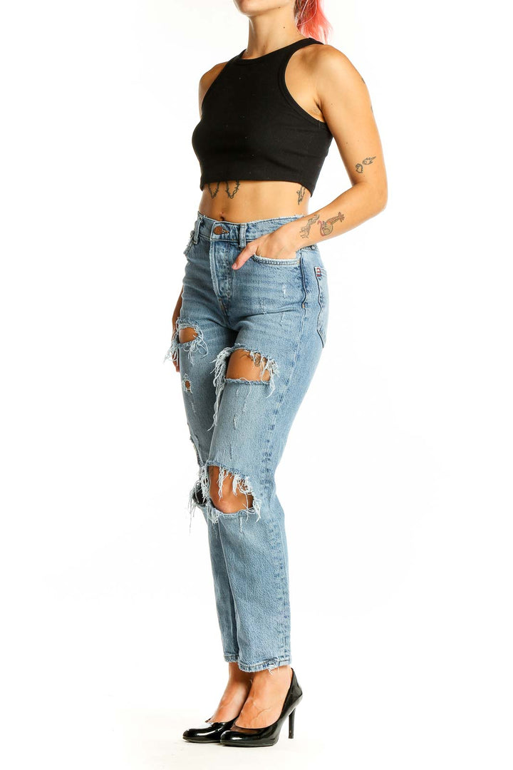 Front view of BDG light blue distressed high-waisted jeans with knee rips