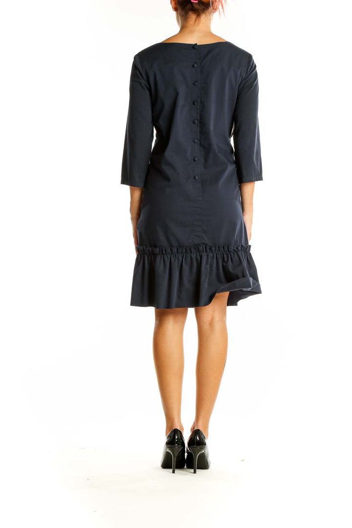 Back view of black SilkRoll dress showing button detail and ruffle hem