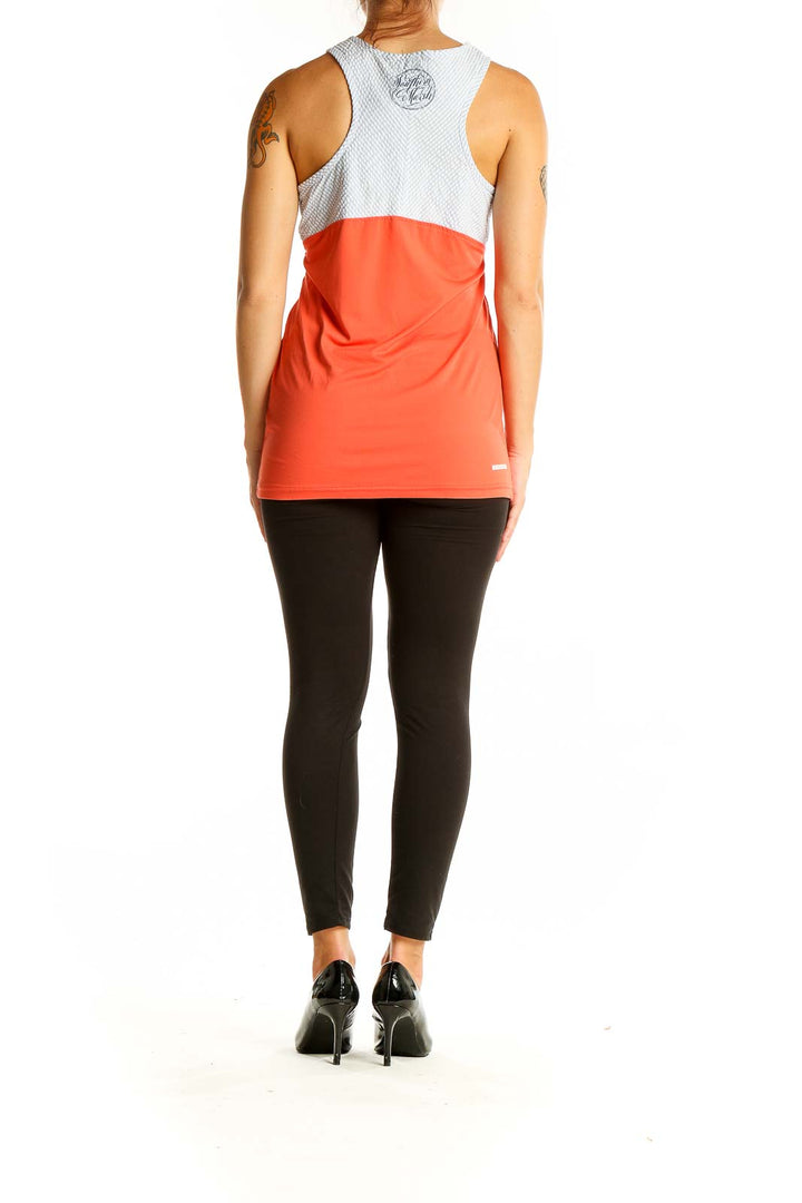 Back view of coral athletic tank top showing racerback design with white mesh upper