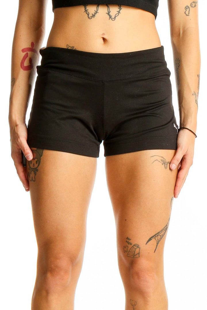 Front view of black Puma athletic shorts on model