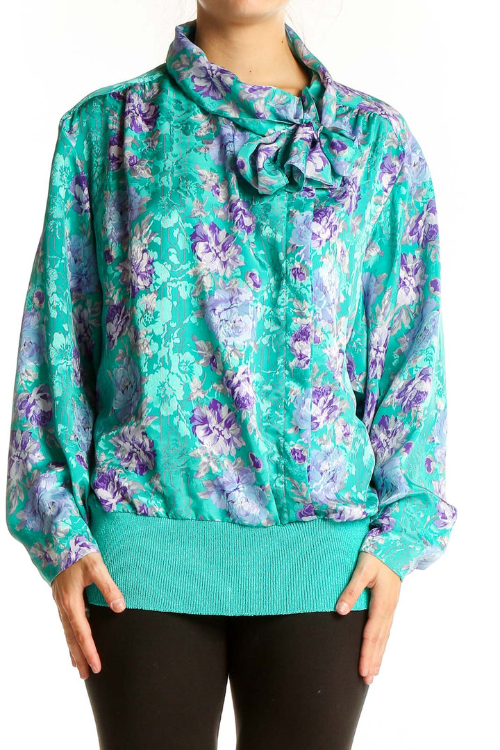 Front view of teal floral print blouse with bow-neck detail