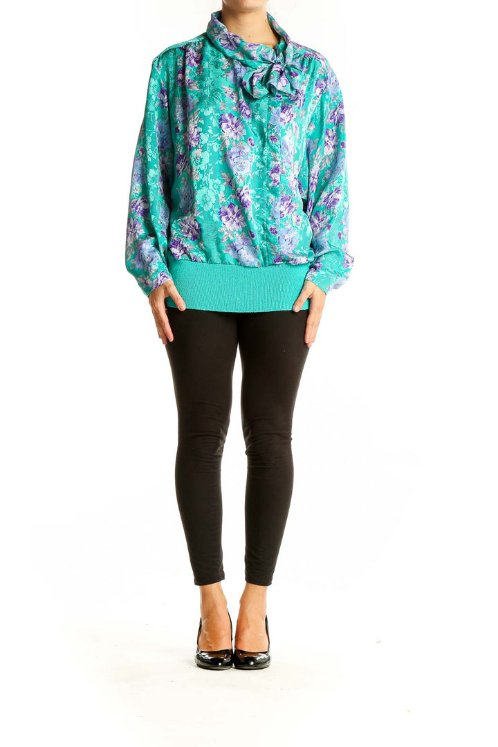 Front view of teal floral print blouse with bow-neck detail