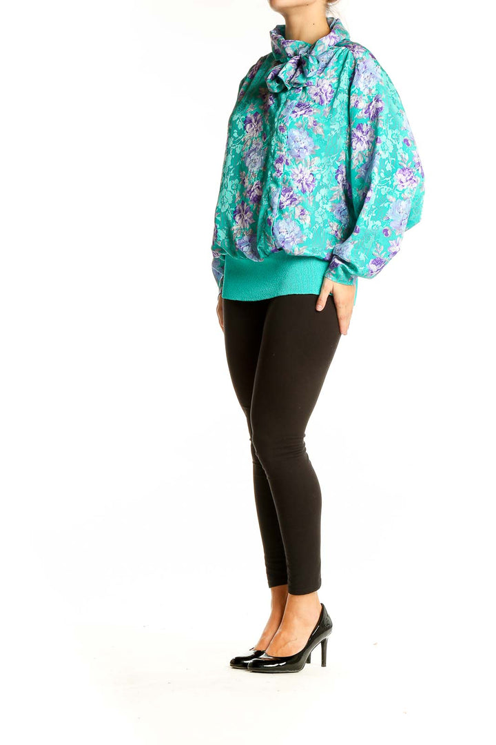 Front view of teal floral print blouse with bow-neck detail