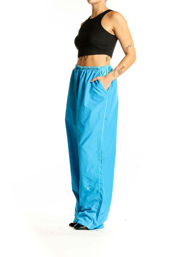 Front view of blue Nike wide-leg track pants