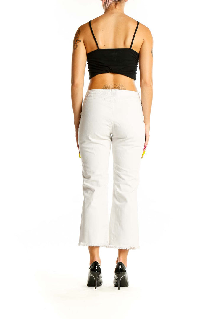 Back view of white cropped denim jeans with frayed hem