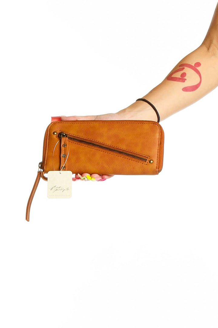 Front view of tan leather zip-around wallet clutch from Free People