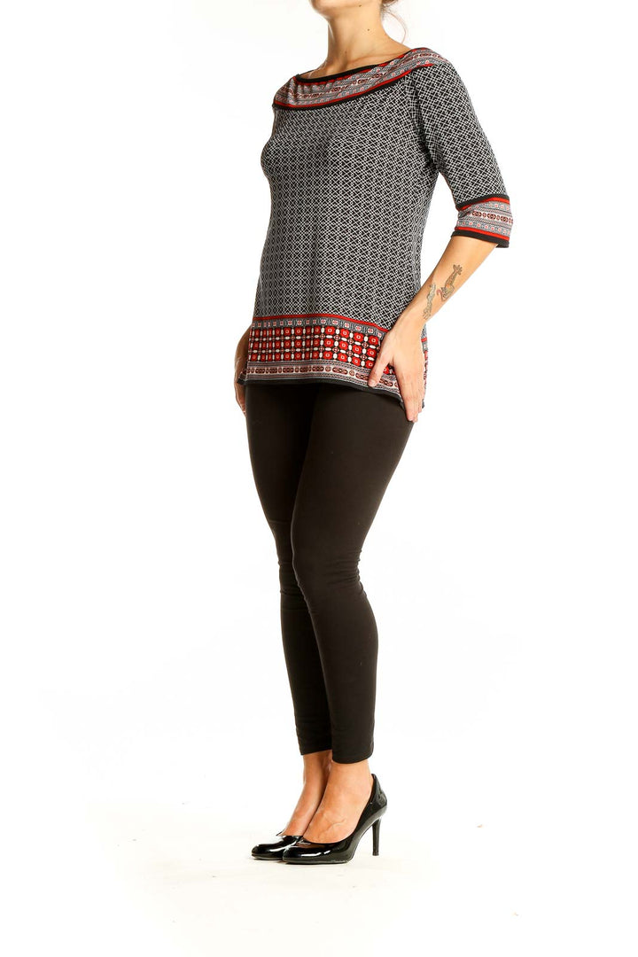 Front view of Max Studio black and white geometric print boatneck top with red accents