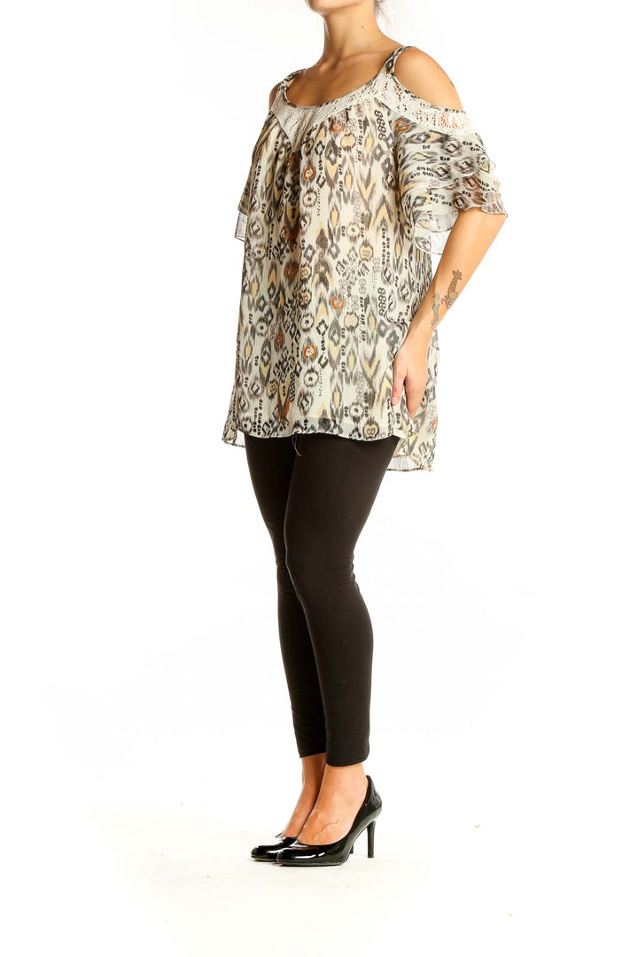 Front view of Daniel Rainn beige ikat print cold shoulder blouse with lace trim