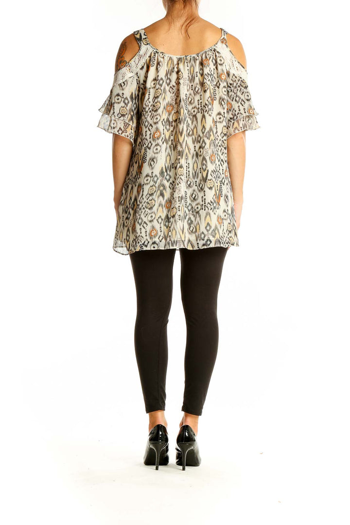 Back view of Daniel Rainn beige ikat print cold shoulder blouse showing flowy silhouette