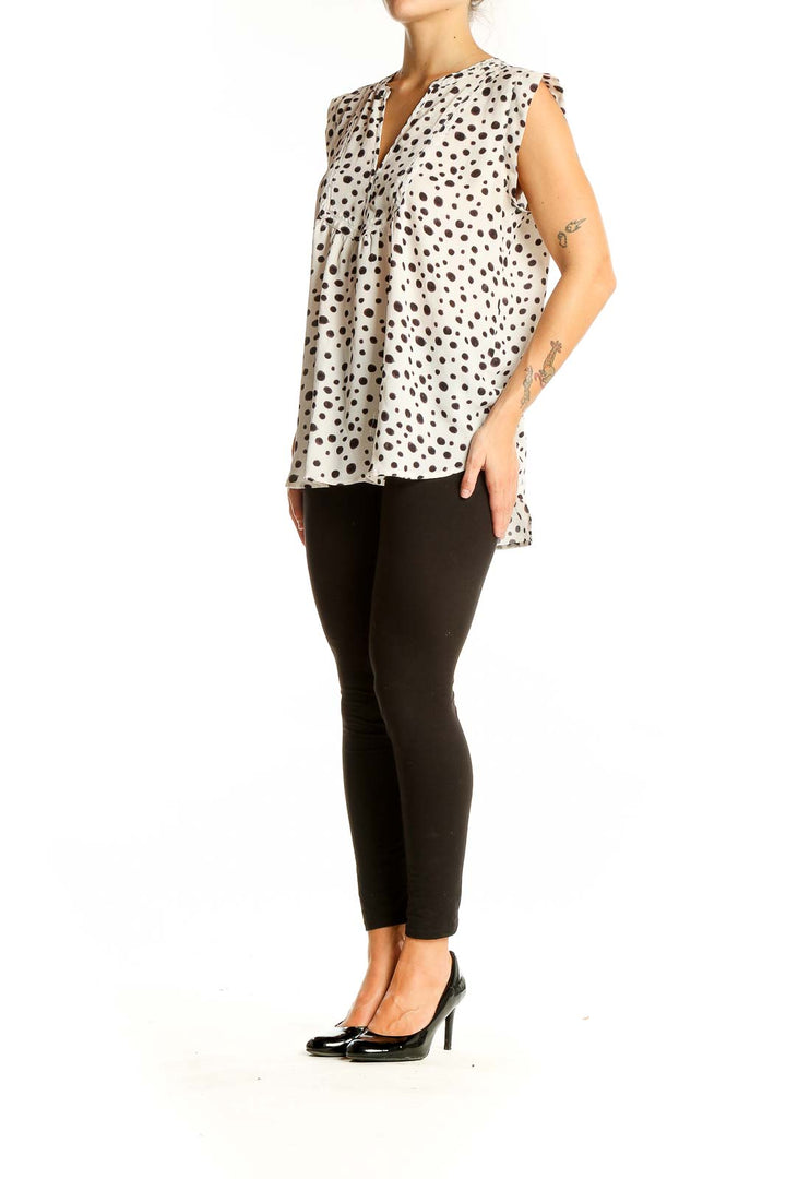 Front view of LOFT white sleeveless blouse with black polka dots and V-neckline