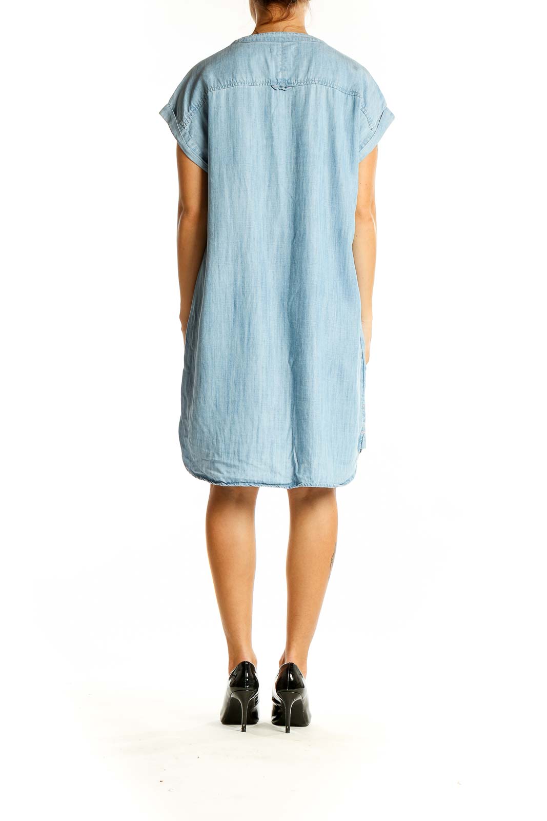 Back view of light blue denim shirt dress showing relaxed fit and high-low hemline