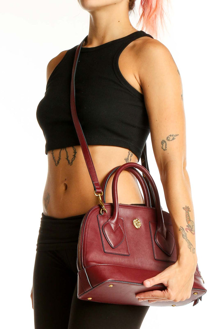 Front view of Anne Klein burgundy leather dome satchel with gold-tone hardware