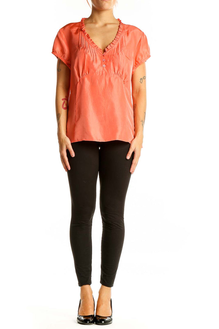 Front view of Ann Taylor coral silk blouse with ruffle-neck and pleated detail