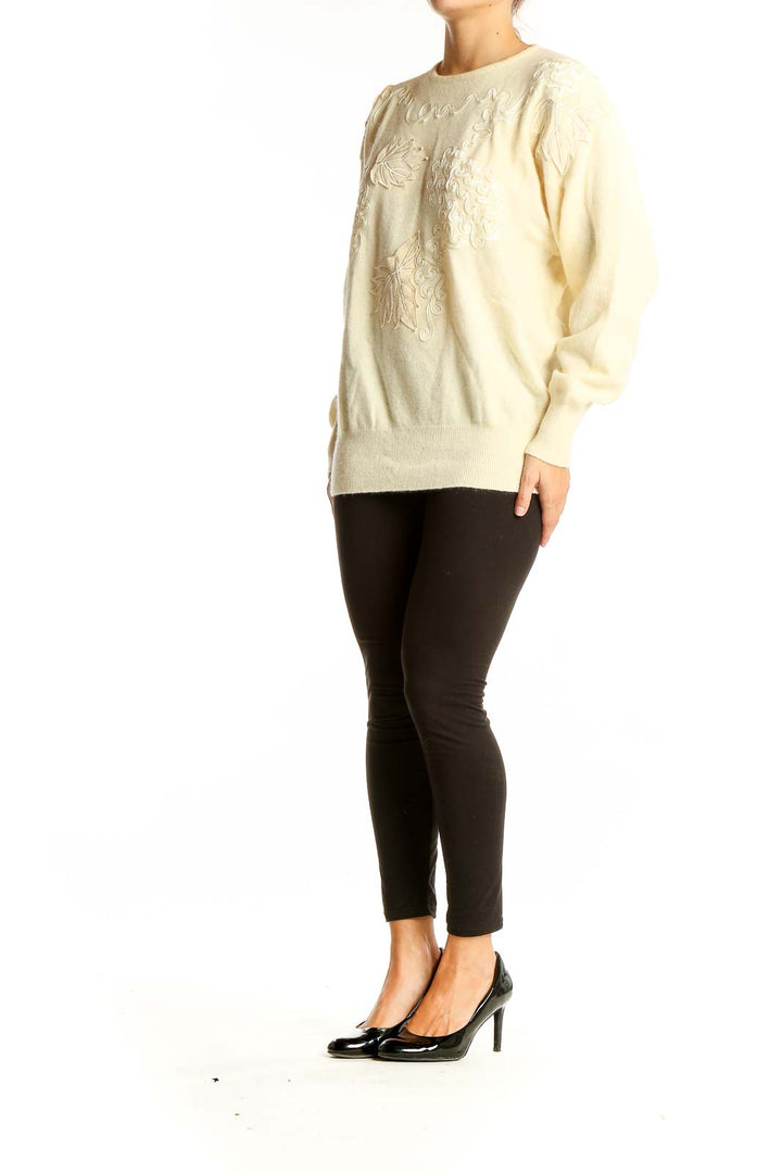 Front view of cream embroidered luxury knit sweater with leaf patterns