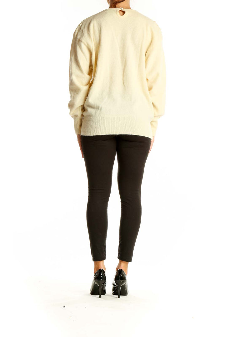 Back view of cream embroidered luxury knit sweater showing relaxed fit