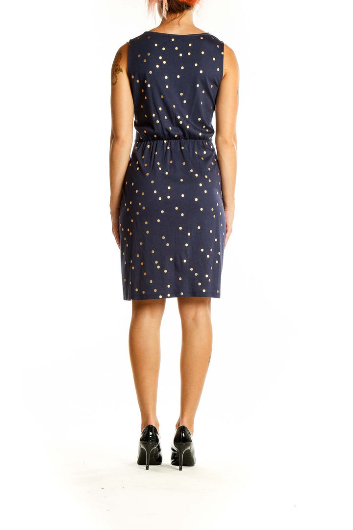 Back view of Boden navy dress with gold polka dots, showing fitted waist