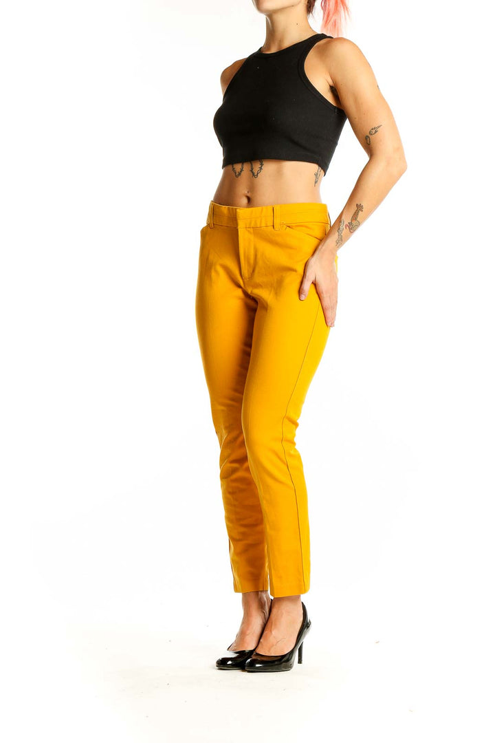 Front view of Gap yellow slim-fit trousers on model