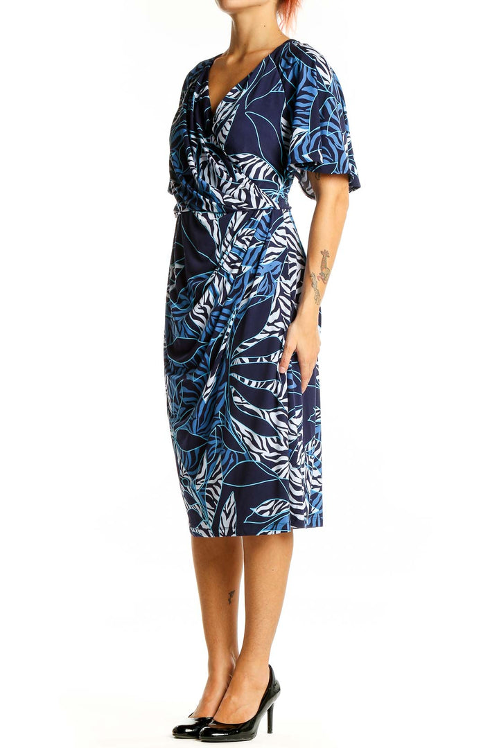 Front view of Maggy London Navy Tropical Print Wrap Midi Dress with V-neckline and flutter sleeves