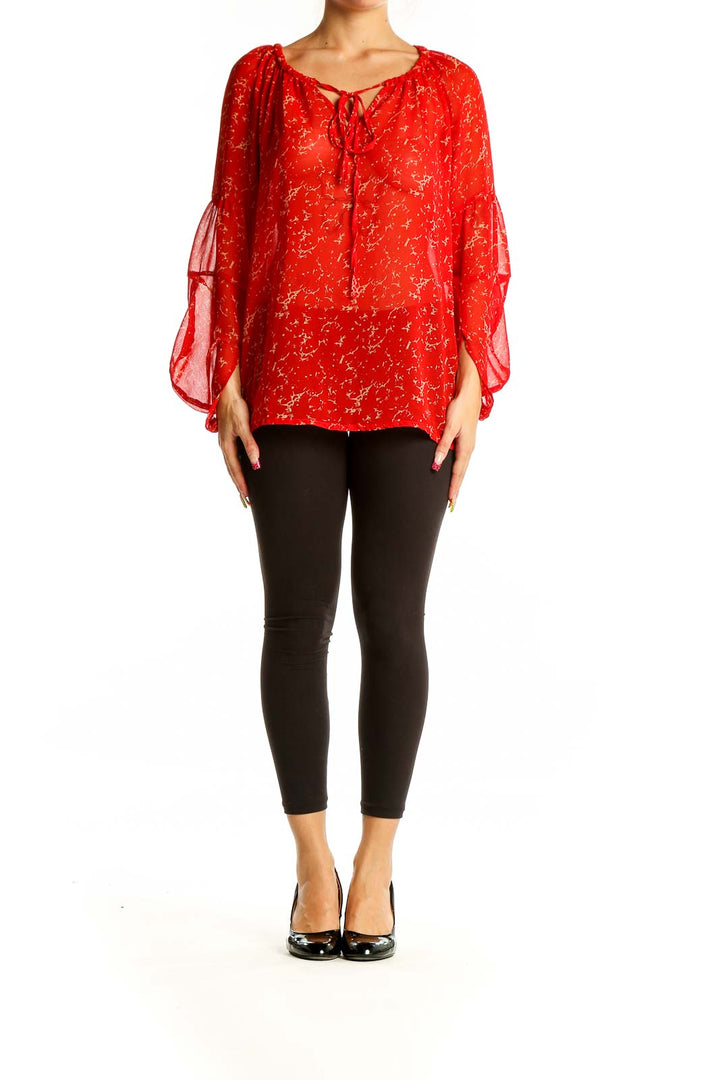 Front view of red sheer peasant blouse with golden floral print and tie neckline