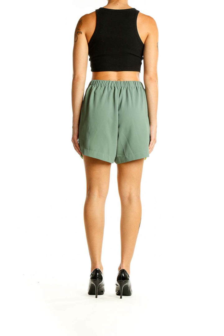 Back view of sage green NAP polyester shorts on model